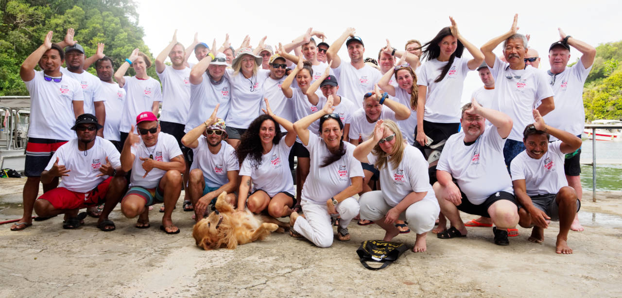 Group of divers at the Fish 'n Fins dock posing for a group photo at the end of Shark Week Palau