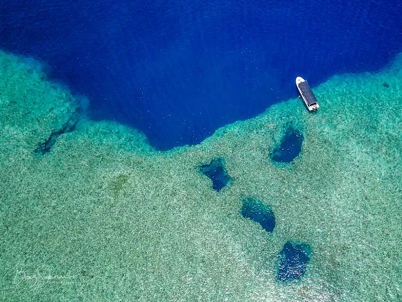 Aerial image of Blue Holes a famous dive site in Palau showing 4 holes in the reef top where divers can enter